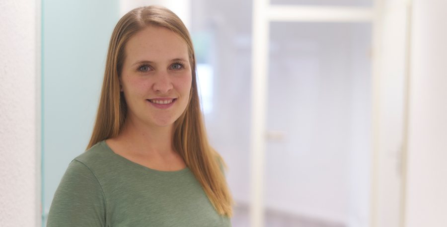 Anna Dehn lächelnd im Flur ihrer Podologie-Praxis
